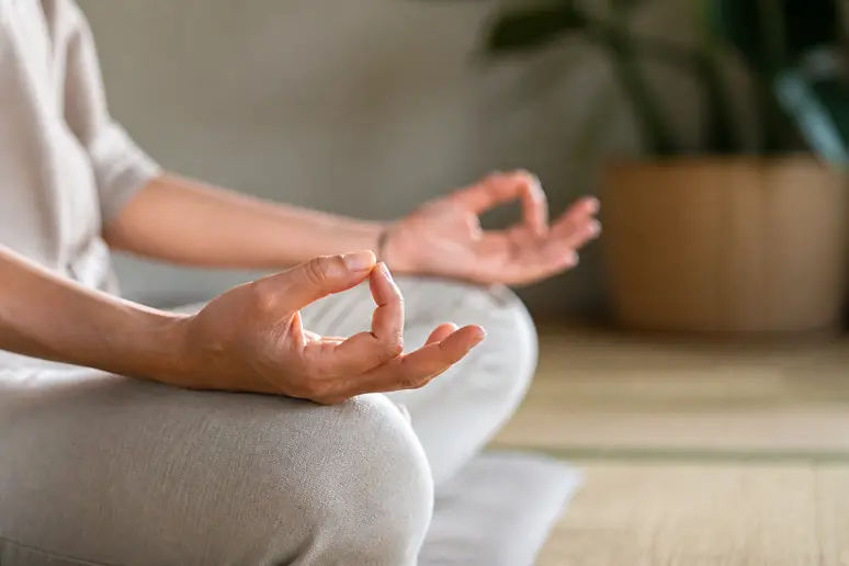Mains pratiquant le chin mudra avec le pouce et l'index délicatement joints.