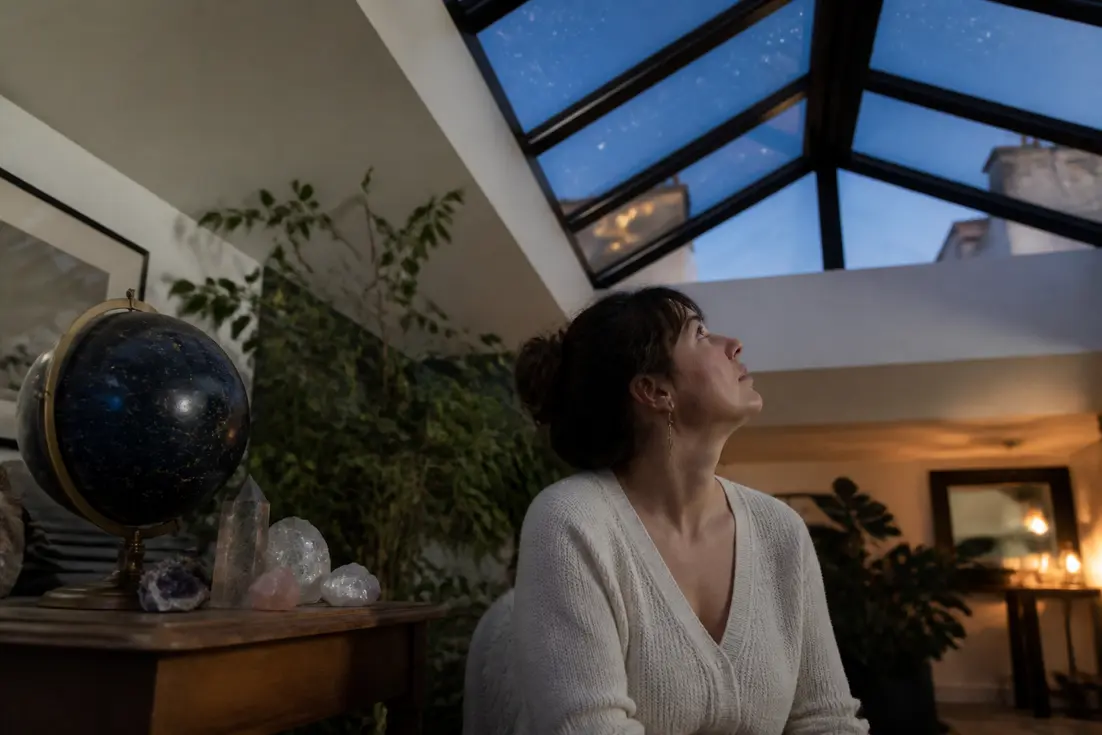 Une femme regarde le ciel nocturne près d'une constellation signe astrologique et de cristaux