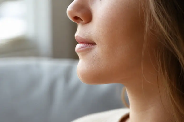 Profil d'une personne concentrée, bouche entrouverte pour une récitation à voix haute.