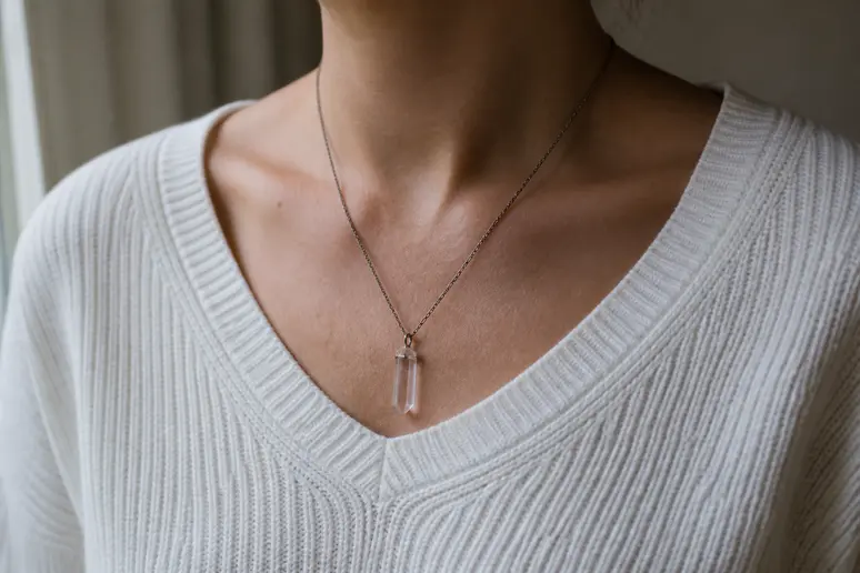 Un pendentif en quartz rose porté discrètement autour du cou pour illustrer la pierre amour couple au quotidien.